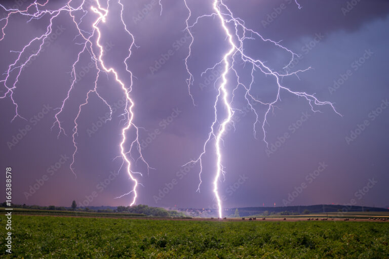 Gewitter in Bildern: Blitze über Feldern und Strommasten